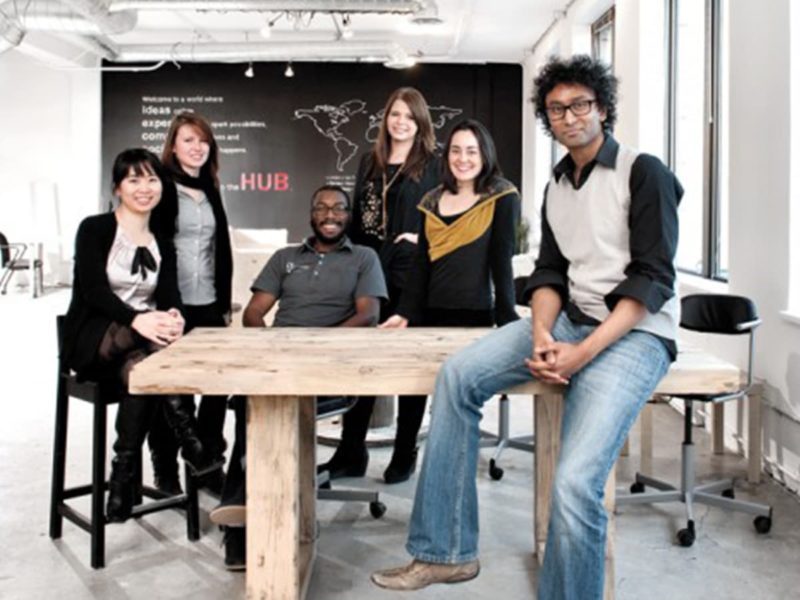 The six diverse founders of Impact Hub Ottawa sitting around a wooden table