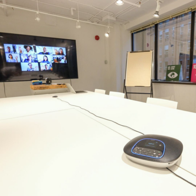 Room set-Up with Video Conferencing equipement and live meeting on large tv screen